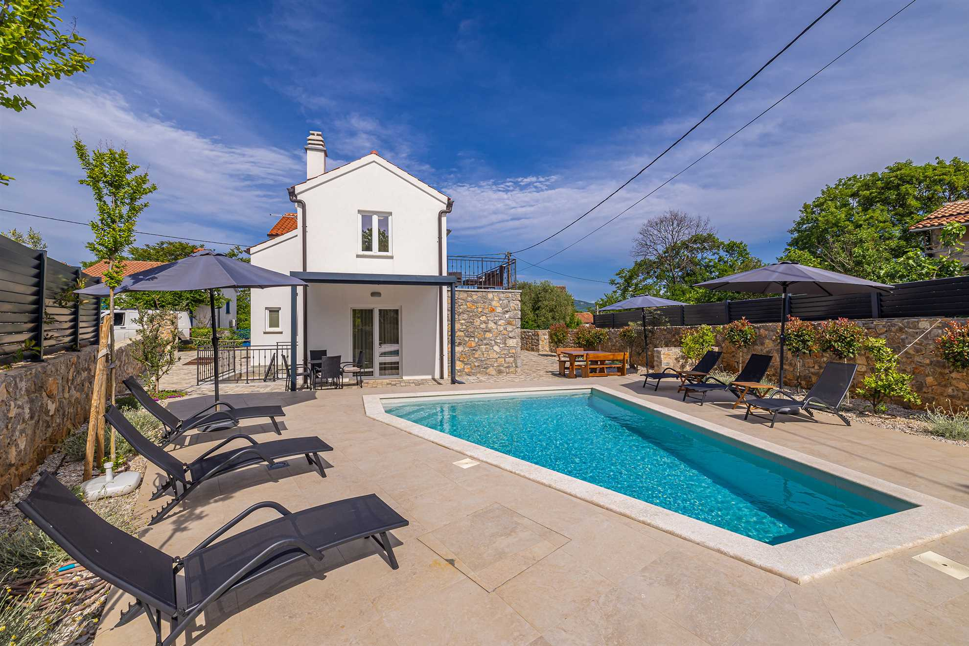 Ferienhaus ANTICA in Lakmartin mit Pool, Sonnenliegen und Sonnenschirm.