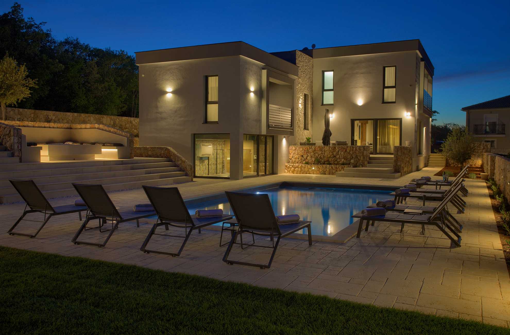 Luxury Villa Astrum with outdoor pool and sun loungers. Night ambiance