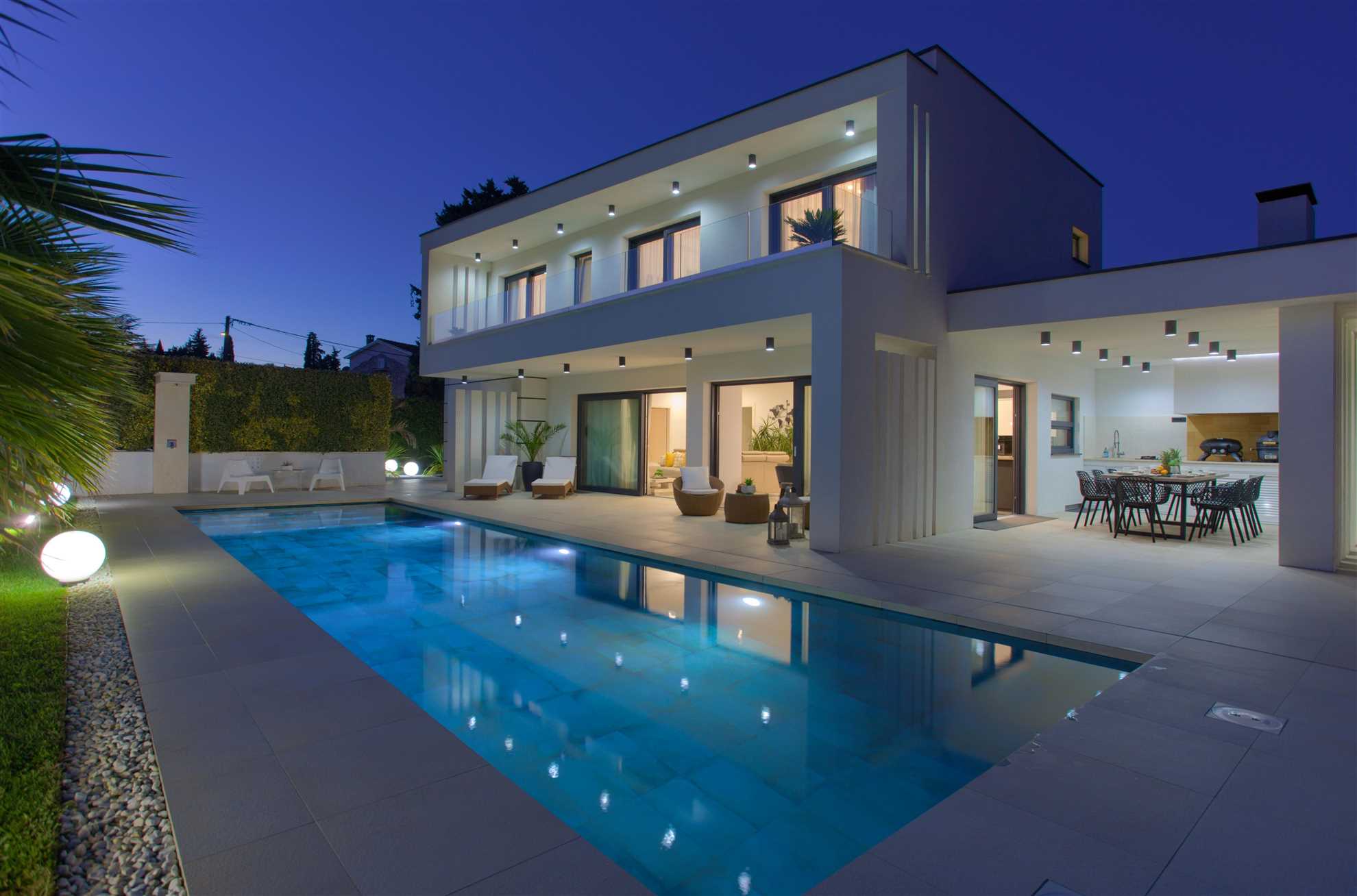 Modern villa Luminosa with outdoor pool, outdoor kitchen and landscaped yard.