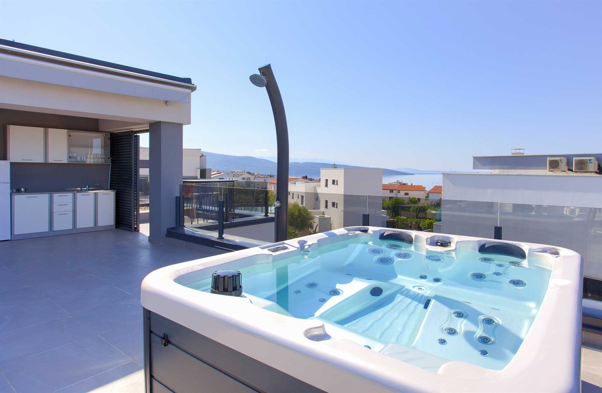 Whirlpool auf privater Terrasse mit Meerblick und modernem Haus
