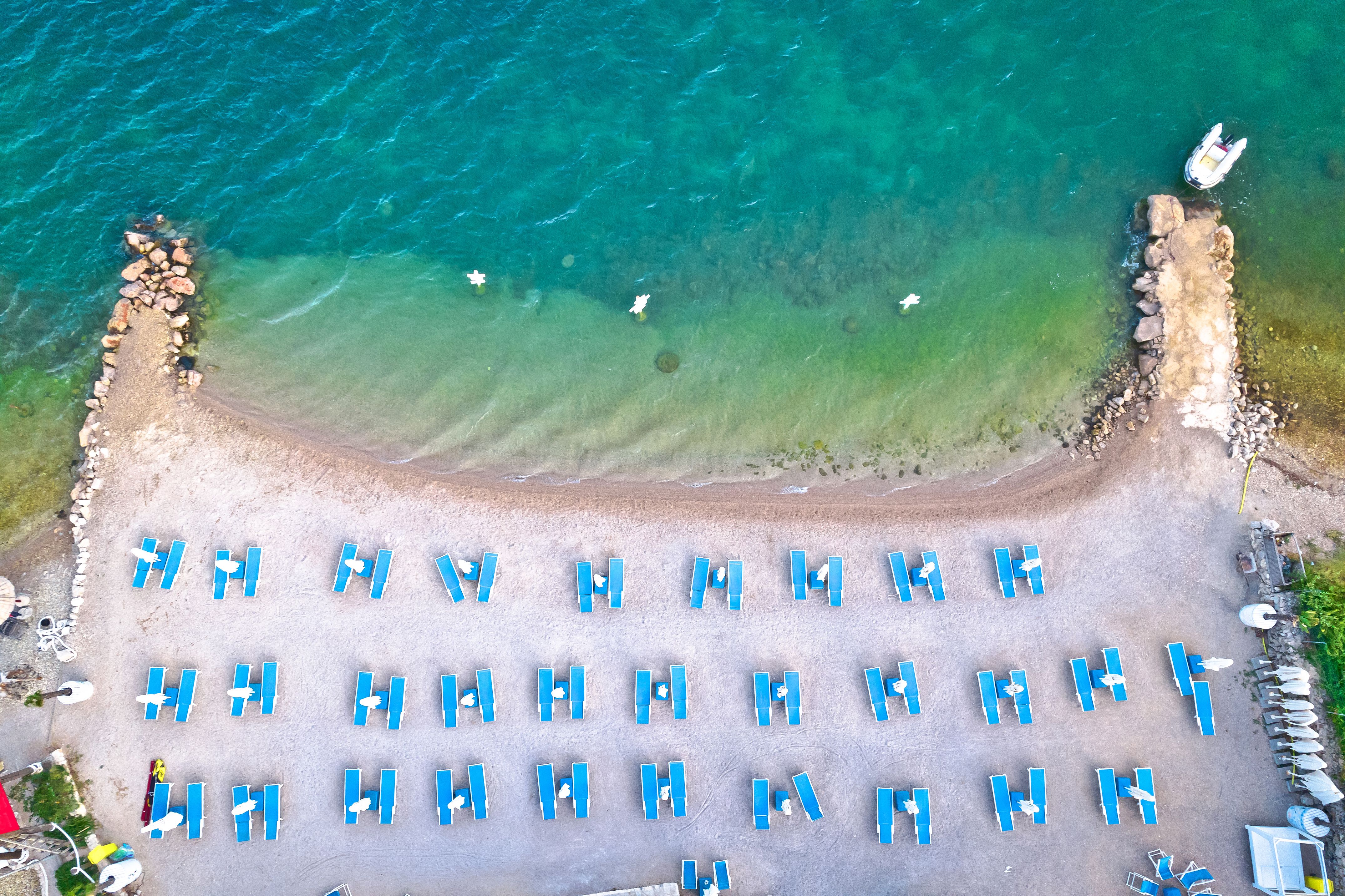 Aerial view of the sea and coastline with blue sun loungers