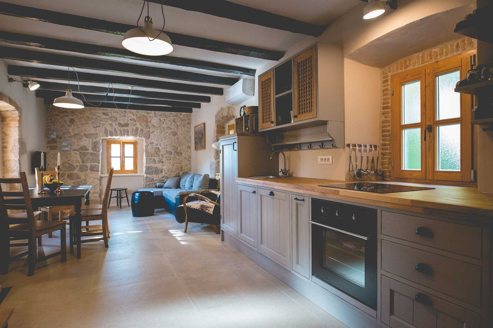 Modern kitchen, dining room with a table and chairs and living room with a sofa and TV.