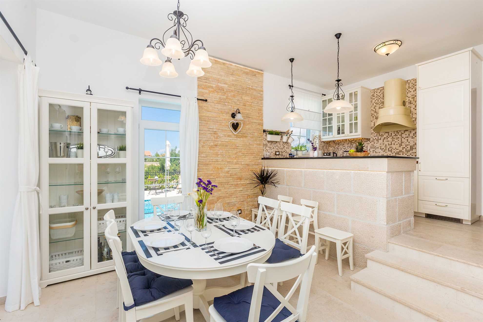 Modern dining room interior with a table, chairs, sideboard and a kitchen.