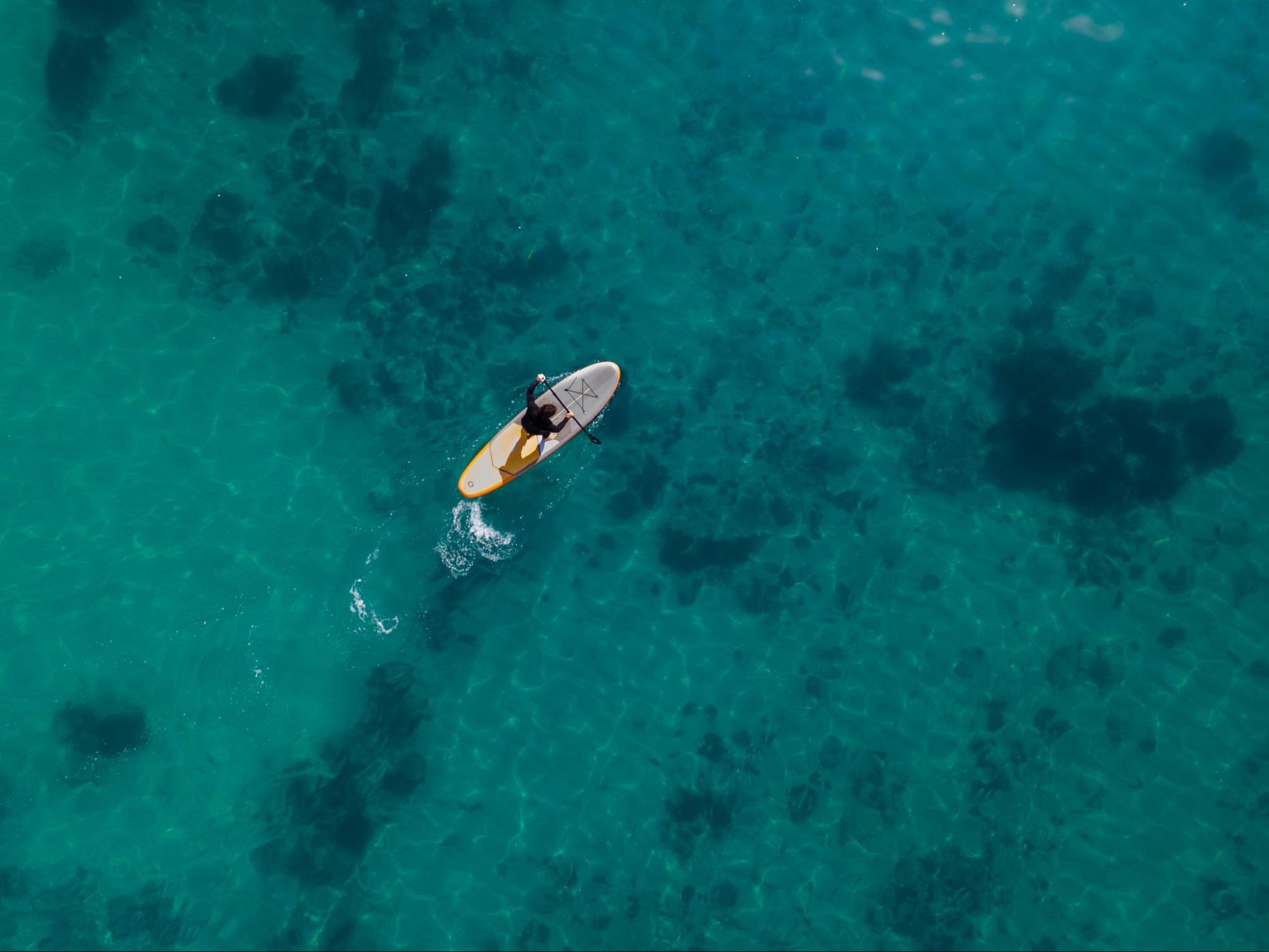 Sky View of a Person Paddling on a Board