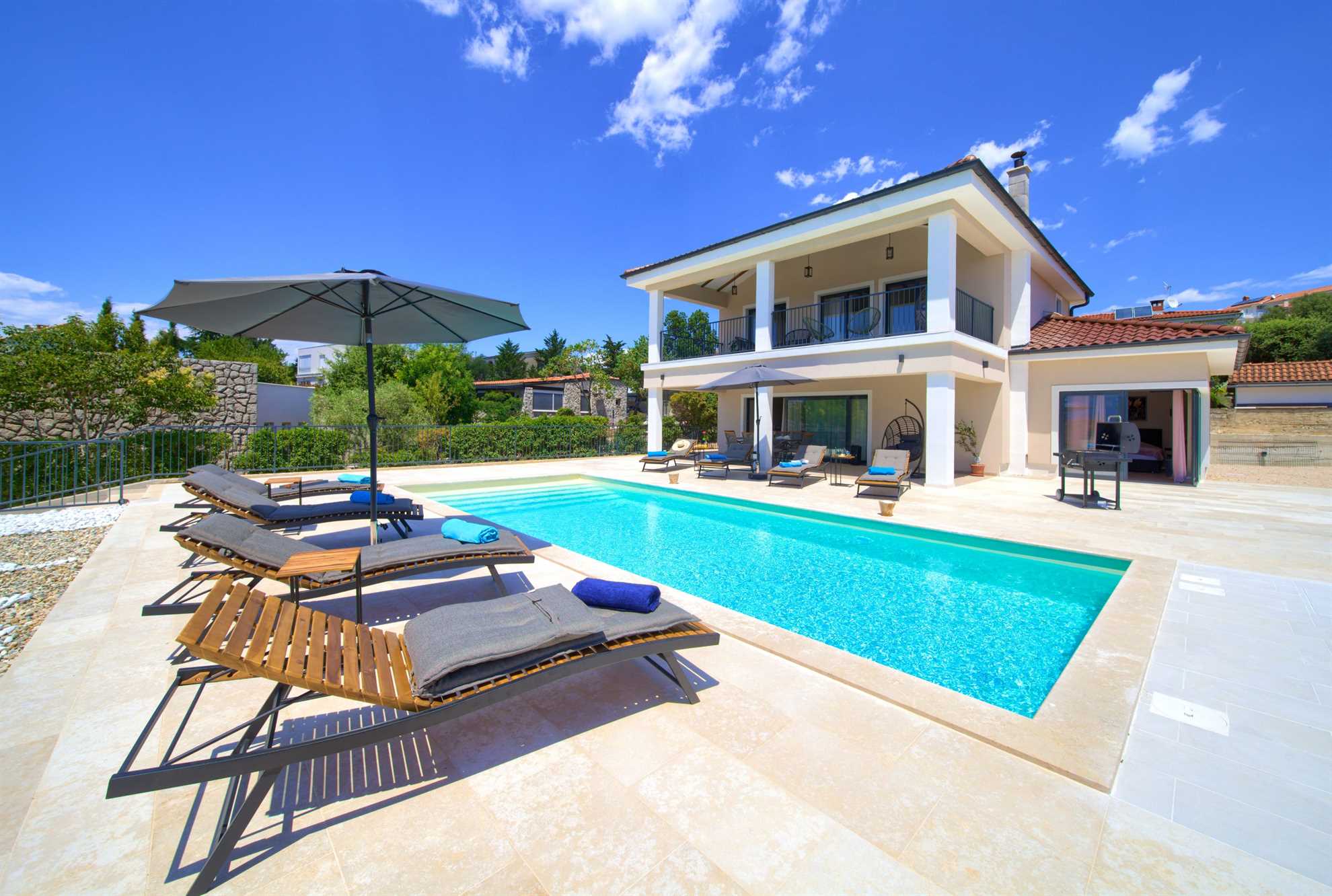 Villa Magnifica with a swimming pool and sun loungers.