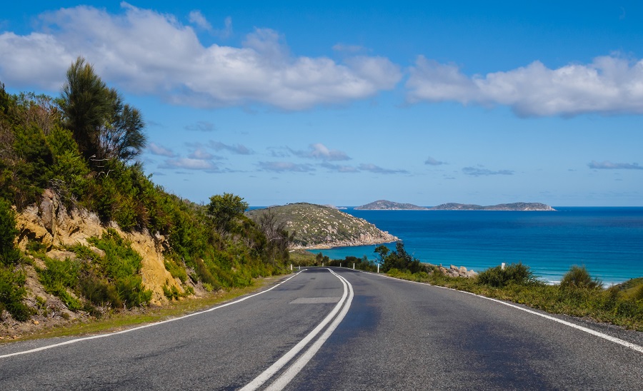 A road with a view of the sea and islands.