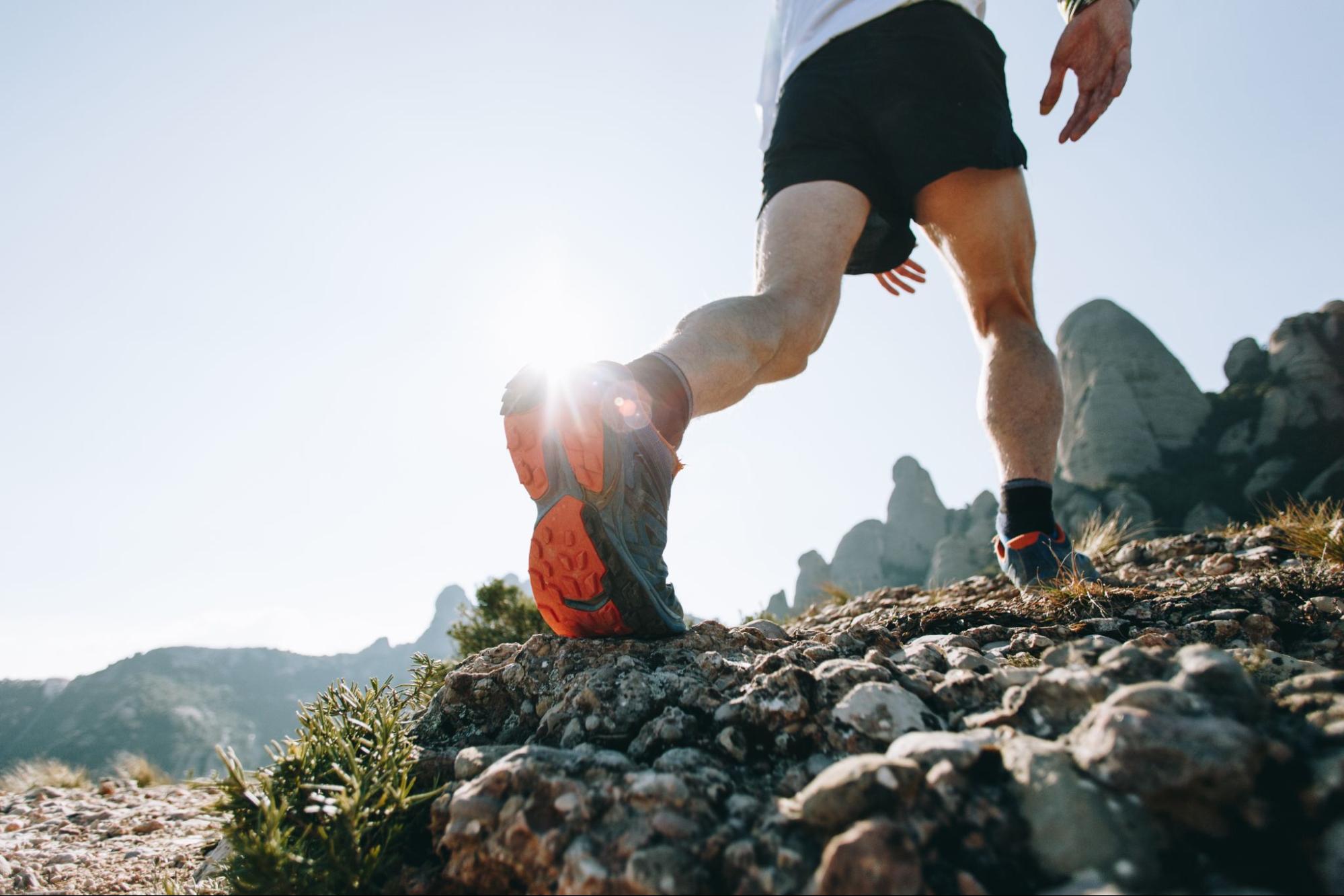 A man runs on rocky ground.