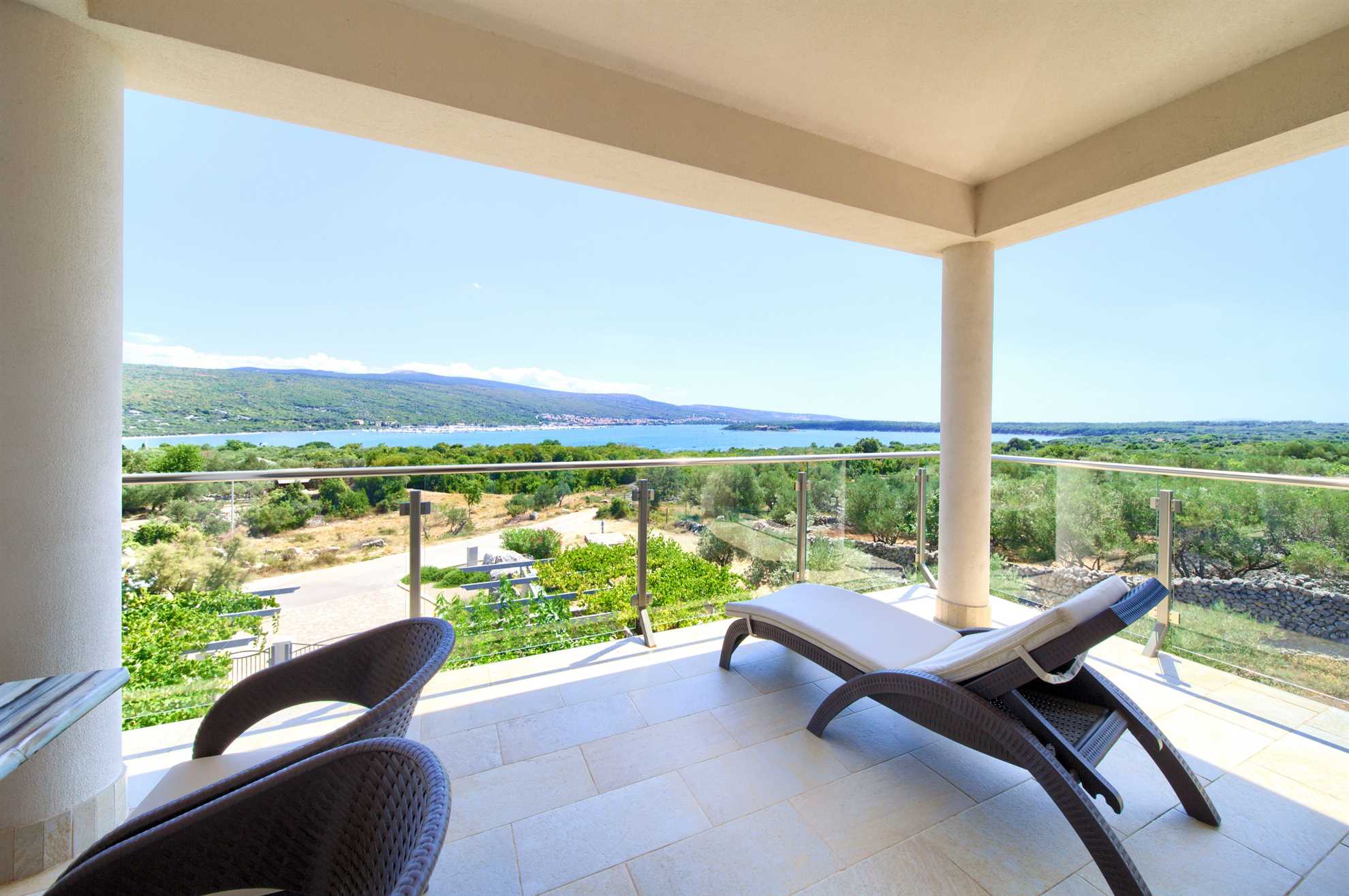 Sunbeds on the terrace of the Royal I apartment with a view of the sea.