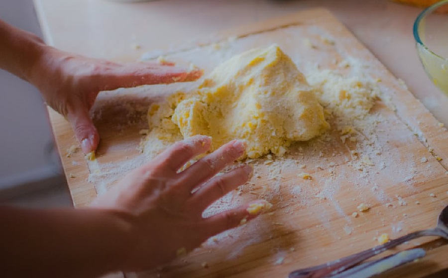 Ženske ruke mijese tijesto za autohtono krčko jelo - šurlice.